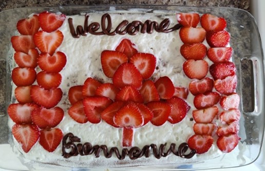 cake with strawbarries on it that says welcome